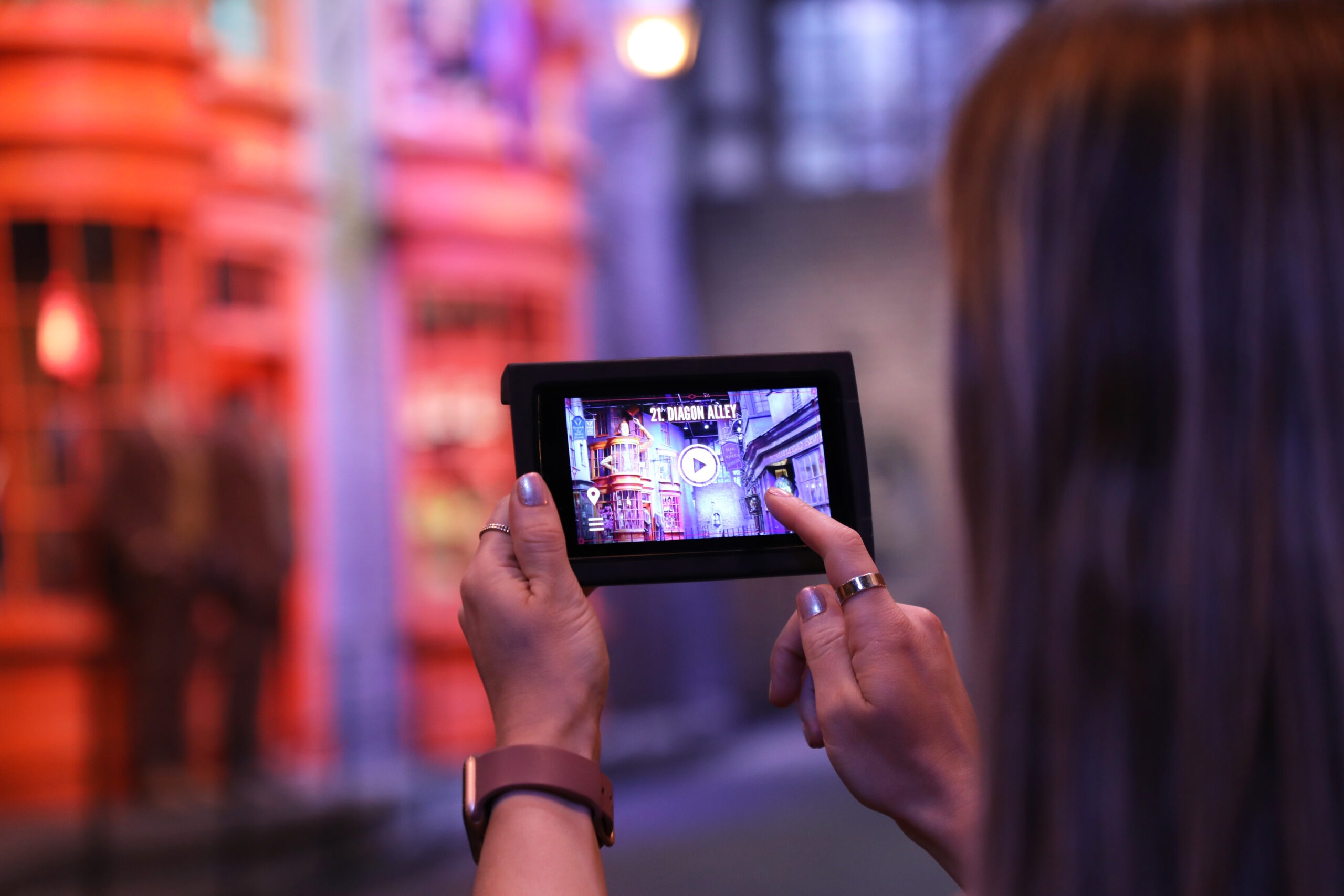 A Studio Tour visitor using a Digital Guide in Diagon Alley.